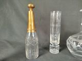 three glass vases and a glass bottle on a table