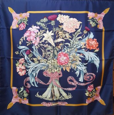 une image représentant un foulard en soie bleu orné d'un bouquet de fleurs