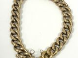 a gold chain bracelet with a lock on a white background