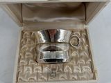 a small silver cup in a box on a table