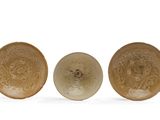 trois assiettes marron ornées de motifs, disposées les unes à côté des autres