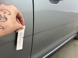 a hand that is holding a sticker on a car door
