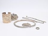 silver jewelry on a white surface with a white background