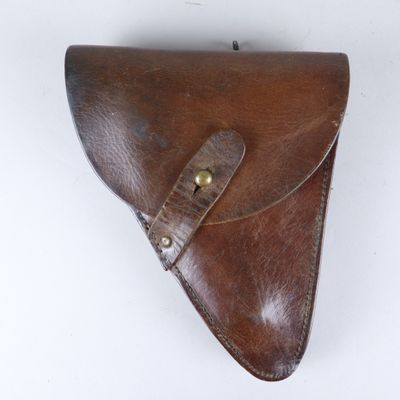 étui en cuir marron avec des finitions en laiton sur fond blanc