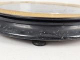 a black and gold plate with a mirror on top of it