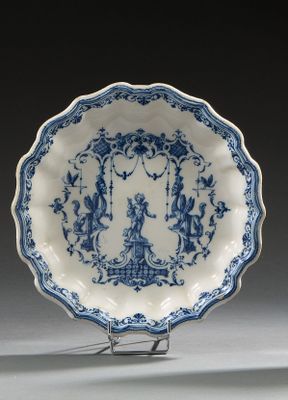 une assiette bleue et blanche ornée de motifs représentant des personnages
