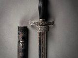 a close up of a sword on a gray background