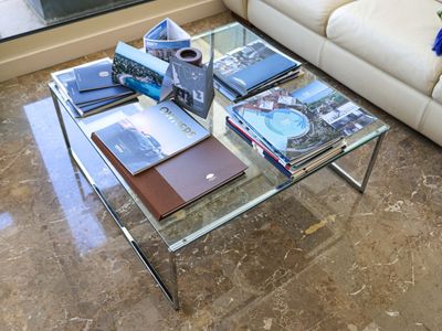 a glass coffee table with a lot of books on top of it