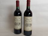 two bottles of red wine sitting next to each other on a table