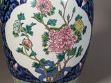 a blue and white vase with pink flowers on it