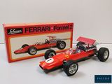 La maquette d'une voiture de course rouge se trouve à côté d'une boîte emballée
