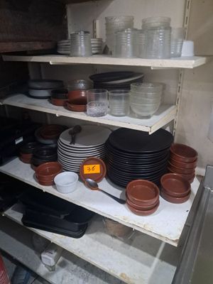 beaucoup d'assiettes et de bols sur les étagères de la cuisine
