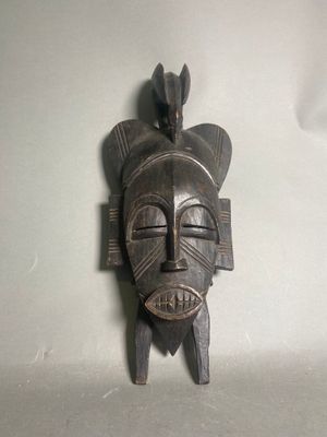 une image d'un masque en bois accroché au mur