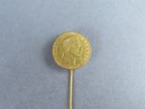 a close up of a gold coin on a stick on a blue surface