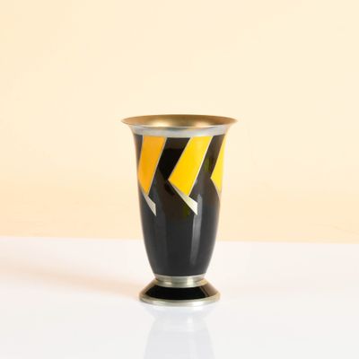 a black vase with a yellow and black design on it