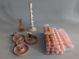 many different types of candles and candlesticks on the table