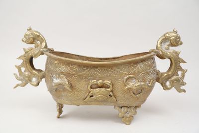 a large brass bowl with a bird and flower decoration on it