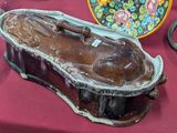 une statue représentant une femme allongée dans une boîte posée sur une table