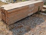 a pile of wood sitting on the ground next to a wall