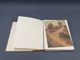 an open book with a picture of a landscape on it