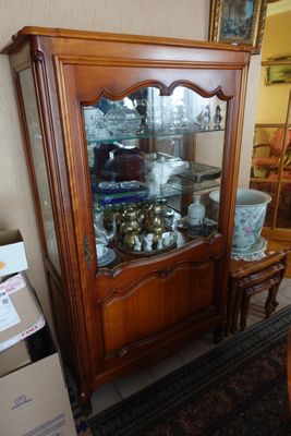 un vaisselier en bois avec une porte vitrée