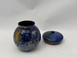 a small blue vase and a small blue vase on a white surface