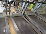 row of treads in a gym room with mirrors on the wall