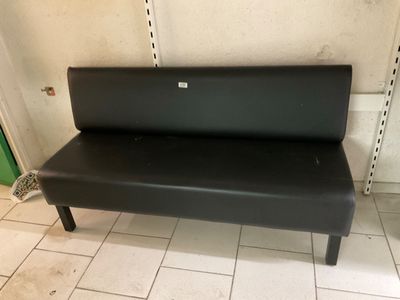 a black bench that is sitting on a tiled floor