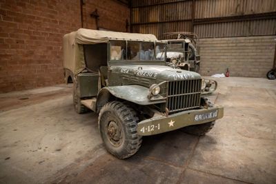 a military truck parked in a garage with a tent on top of it