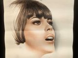 poster of a woman with short brown hair and bangs on a black background