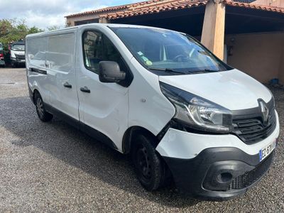 La camionnette blanche est garée devant un garage.