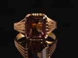 une image représentant une bague en or sertie d'une pierre violette