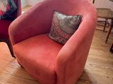 a pink chair and a red chair in a living room