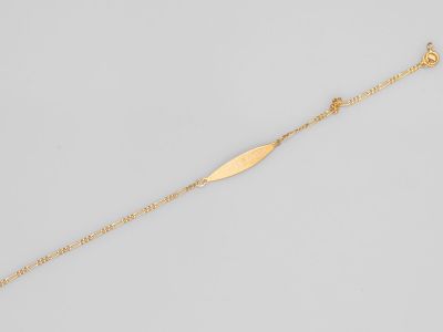 un bracelet plaqué or orné d'une breloque en forme de feuille