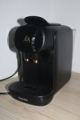 une machine à café noir posée sur une table en bois