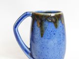 a blue coffee mug with a brown handle on a white surface