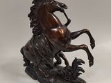 statue en bronze représentant un cheval dressé sur ses pattes arrière, sur fond blanc