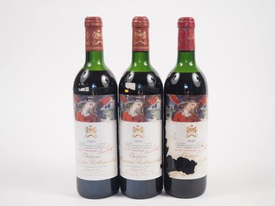 trois bouteilles de vin posées les unes à côté des autres sur une surface blanche