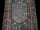 un tapis bleu orné d'un motif en médaillon et de franges