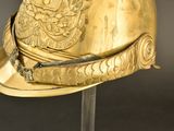 a gold helmet on a metal stand with a black background
