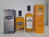 three bottles of eddu and a box on a table