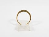 a gold ring on a clear stand on a white surface