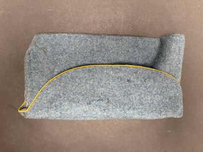 grey felt pouch with yellow zipper on brown background