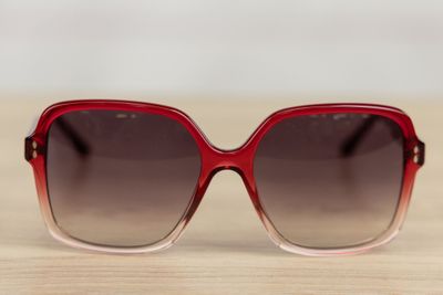 sunglasses on a wooden table with a white wall in the background