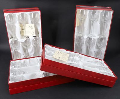 three empty wine glasses in a red gift box on a black background
