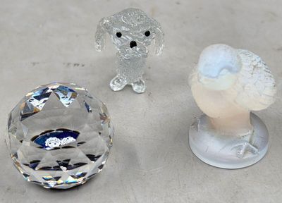 trois figurines en cristal posées les unes à côté des autres sur une table