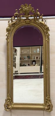 un miroir doré accroché au mur dans une salle de bains