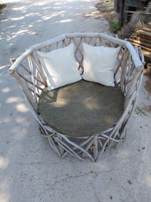 a chair made out of sticks with pillows on top of it