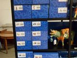 une étagère noire sur laquelle se trouvent des boîtes bleues et une figurine de vache