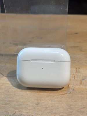 des AirPods d'Apple posés sur une table à côté d'une boîte transparente